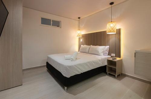a bedroom with a bed and a night stand and lights at Hotel Blu Sai in San Andrés