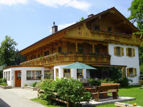 uma casa com uma varanda, uma mesa e bancos em Zwergerlhof em Loich