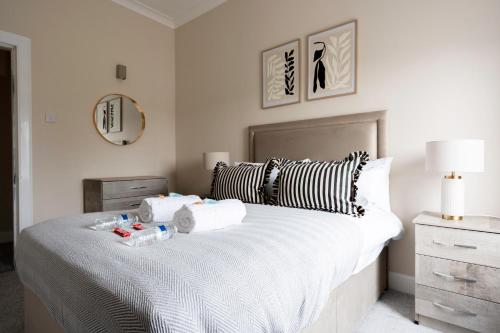 a bedroom with a large bed with two towels on it at Station Road Stays in Kirk of Shotts