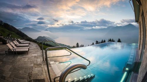 a swimming pool with a view of a mountain at Hotel Villa Honegg in Ennetbürgen