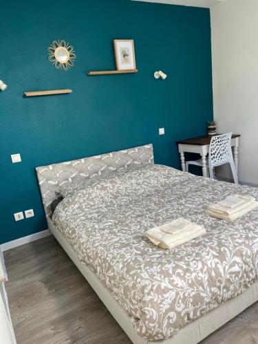 Ce lit se trouve dans une chambre dotée d'un mur bleu. dans l'établissement Comfortable duplex apartment, à Agen