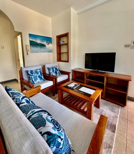 un soggiorno con divano e TV a schermo piatto di Torre Mar Galapagos Boutique Suites a Puerto Ayora