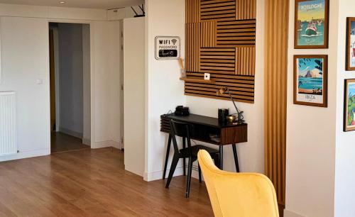 Cette chambre comprend un bureau et une chaise jaune. dans l'établissement L'Appart du Quai - Centre ville, Port, Nausicaá, à Boulogne-sur-Mer