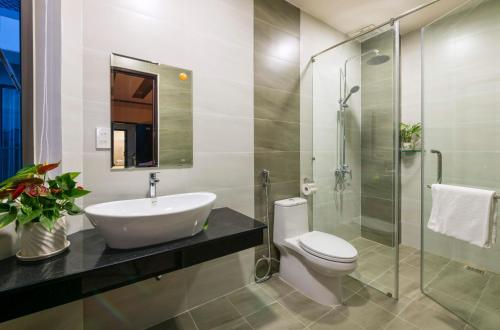 une salle de bain avec un lavabo, des toilettes et une douche dans l'établissement Hoài River Hội An Homestay Sông Hoài Homestay 250m walk to the center Old Town, à Hội An