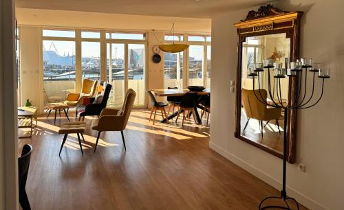 une salle à manger avec une table, des chaises et un miroir dans l'établissement L'Appart du Quai - Centre ville, Port, Nausicaá, à Boulogne-sur-Mer
