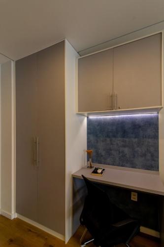 a kitchen with a desk and a cupboard at Garden on Blue Studio - GRU 303 in Guarulhos