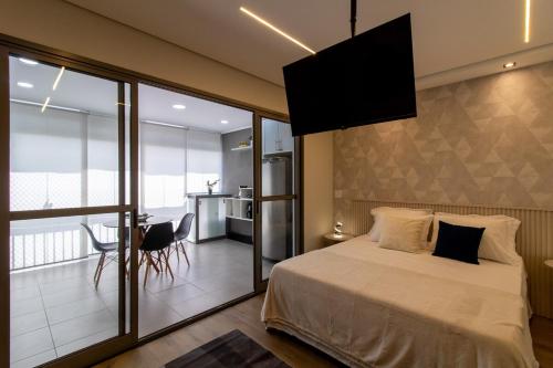 a bedroom with a large bed and a balcony at Garden on Blue Studio - GRU 303 in Guarulhos