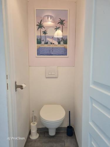 une salle de bain avec toilettes et un tableau au mur dans l'établissement Goodlife - à 5 min à pieds de la mer avec balcon & parking - By AURAconciergerie, à Saint-Cyr-sur-Mer