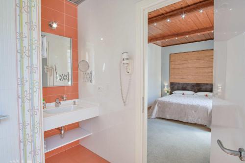 a bathroom with a sink and a bed at Albergo Diffuso - Il Poggetto tra Urbino & San Marino in Urbino