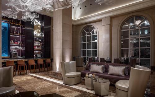 a bar with a couch and chairs in a room at Hotel Crescent Court in Dallas