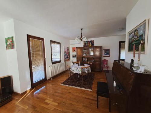 Una sala de estar con una mesa y un comedor. en Green house, en Bileća