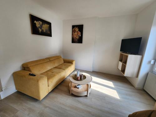 a living room with a couch and a coffee table at Le cocon de Charlotte in Gray