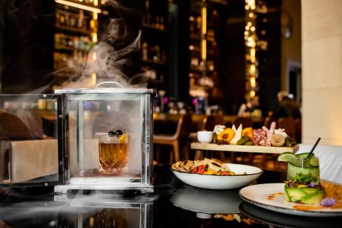 a table with a drink and a plate of food at Hotel Crescent Court in Dallas