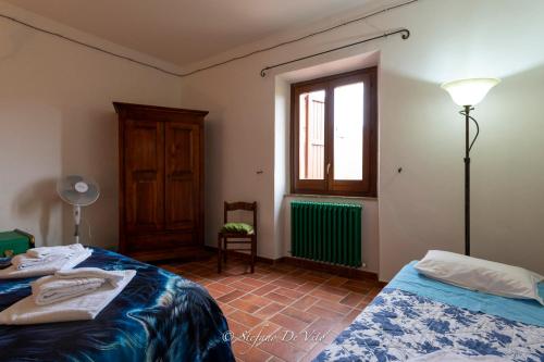 a bedroom with two beds and a window at Il Borgo Del Lupo Relax Family Apartments in Tuscany with Restaurant & Swimming Pool in Sarteano