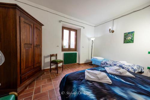 a bedroom with two beds and a cabinet at Il Borgo Del Lupo Relax Family Apartments in Tuscany with Restaurant & Swimming Pool in Sarteano