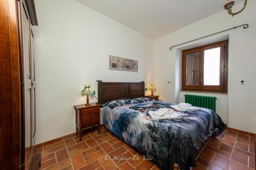 a bedroom with a bed and a table and a window at Il Borgo Del Lupo Relax Family Apartments in Tuscany with Restaurant & Swimming Pool in Sarteano