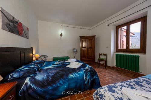 a bedroom with a bed with a blue blanket at Il Borgo Del Lupo Relax Family Apartments in Tuscany with Restaurant & Swimming Pool in Sarteano