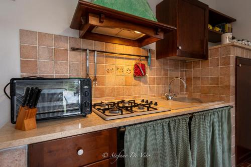 a kitchen counter with a toaster oven and a microwave at Il Borgo Del Lupo Relax Family Apartments in Tuscany with Restaurant & Swimming Pool in Sarteano