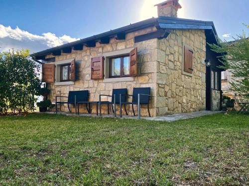 a stone house with a table and chairs in front of it at Sole's House in Verzuno