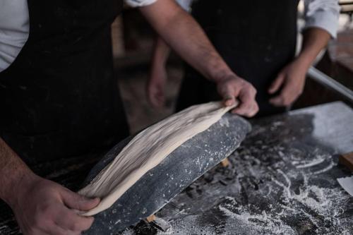 two people are making a piece of dough at Tsinandali Estate, A Radisson Collection Hotel in Tsinandali