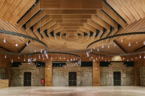a large room with a wooden ceiling and chandeliers at Tsinandali Estate, A Radisson Collection Hotel in Tsinandali