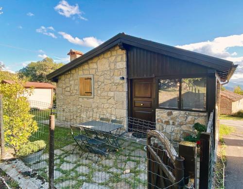 a small stone house with a fence in front of it at Sole's House in Verzuno