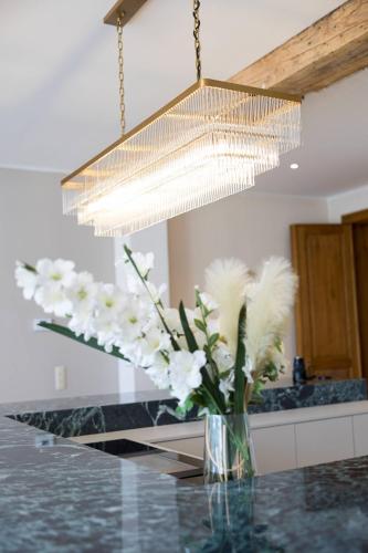 a vase of white flowers sitting on a counter under a chandelier at Unique Flat on the GRAND PLACE in Brussels