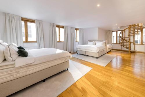 a white bedroom with two beds and a staircase at Unique Flat on the GRAND PLACE in Brussels