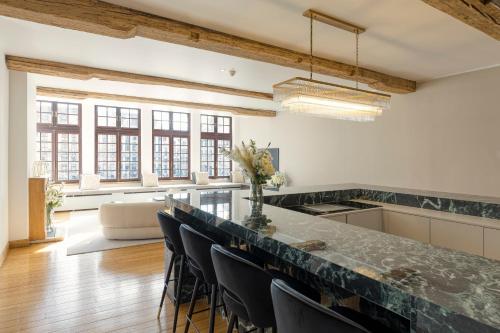 a large kitchen with a large counter with chairs at Unique Flat on the GRAND PLACE in Brussels
