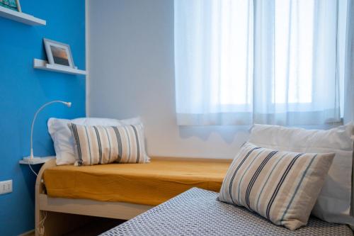 a bedroom with a bed with pillows and a window at Costa est house in Piombino