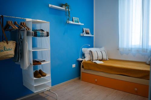 a bedroom with a bed and a blue wall at Costa est house in Piombino