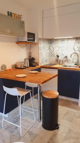 une cuisine avec une table en bois et deux chaises dans l'établissement Suite Voile Clim Wifi Terrasse Plages 2min - ROSSIconciergerie - Linge inclus, à La Grande Motte