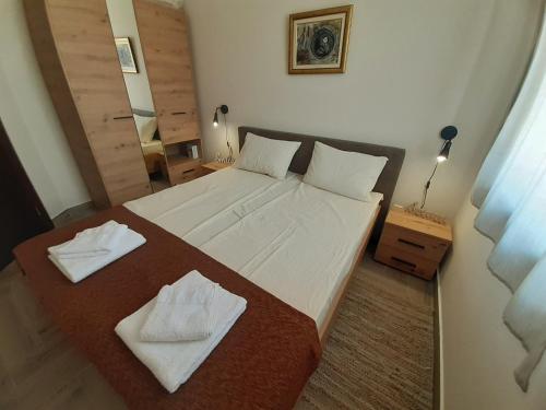 a bedroom with a large bed with two towels on it at Dunavski kutak in Veliko Gradište