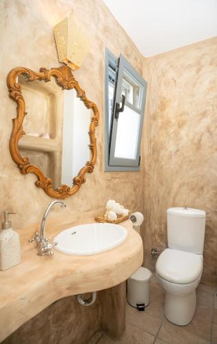 a bathroom with a sink and a mirror and a toilet at Semini Villa in Kalymnos