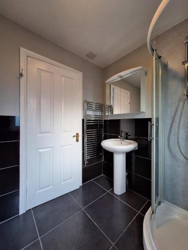 a bathroom with a sink and a shower and a mirror at Dunuaran in Oban