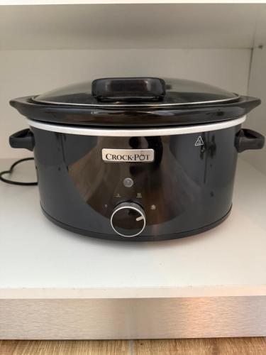 a black slow cooker sitting on top of a counter at Cozy Spot in Deva