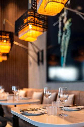 a group of tables with wine glasses and lights at Radisson Blu Hotel at Porsche Design Tower Stuttgart in Stuttgart