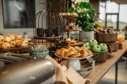 a buffet with bread and pastries on a table at Radisson Blu Hotel at Porsche Design Tower Stuttgart in Stuttgart