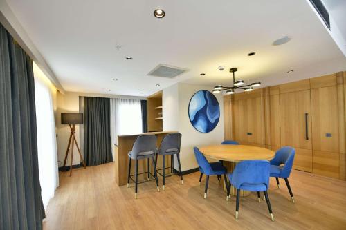 a dining room with a table and blue chairs at Radisson Hotel Mersin in Mersin