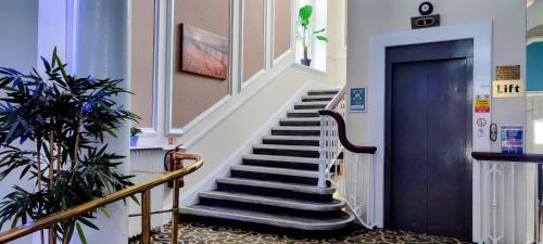 a staircase in a building with a blue door at The Grand Hotel in Llandudno