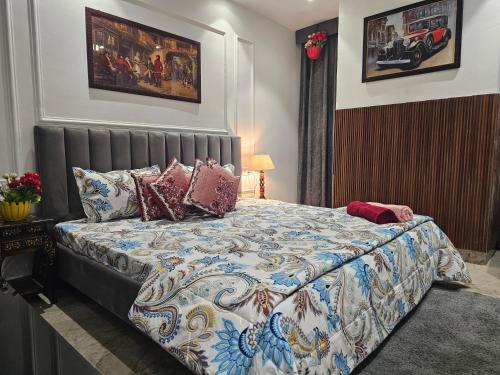 a bedroom with a bed with a quilt and pillows at Ultra Luxury Cool Flat By Bliss Stay in Ghaggar