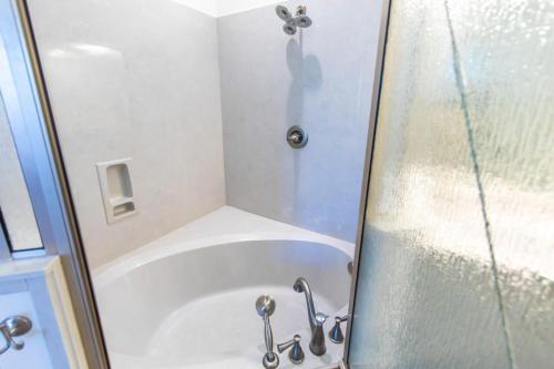 a shower stall with a white tub in a bathroom at Journeys End 101 in Coffeyville