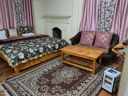 a living room with a couch and a bed and a table at Ta Zong homestay in Dirang Dzong