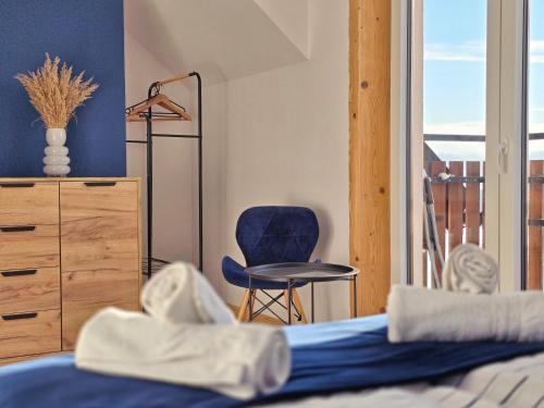 a bedroom with a bed and a blue chair at Babiakówka in Kluszkowce