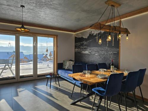 a dining room with a table and blue chairs at Babiakówka in Kluszkowce