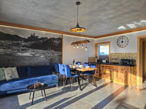 a living room with a blue couch and a table at Babiakówka in Kluszkowce