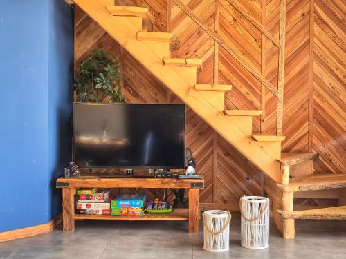 a living room with a television on a wooden wall at Babiakówka in Kluszkowce