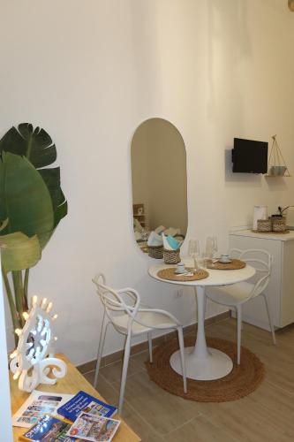 a table and chairs in a room with a mirror at Molly's Home Otranto in Otranto