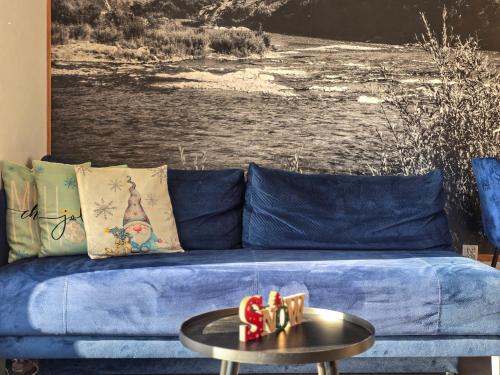 a blue couch with a table in a living room at Babiakówka in Kluszkowce
