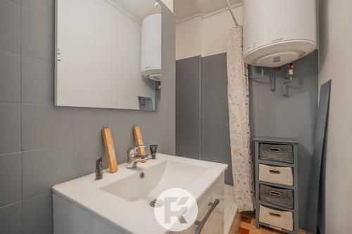 une salle de bain avec un lavabo blanc et un miroir dans l'établissement R Apparts T4 Sweet Home, à Grenoble